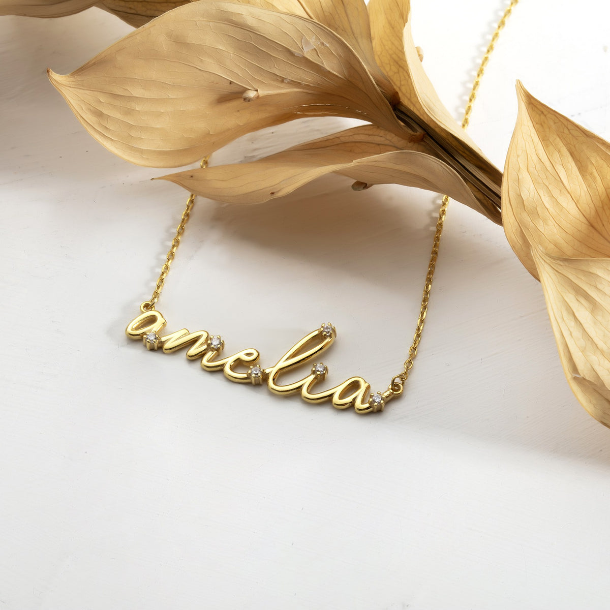Gold cursive name necklace with sparkling CZ stones on a cable chain