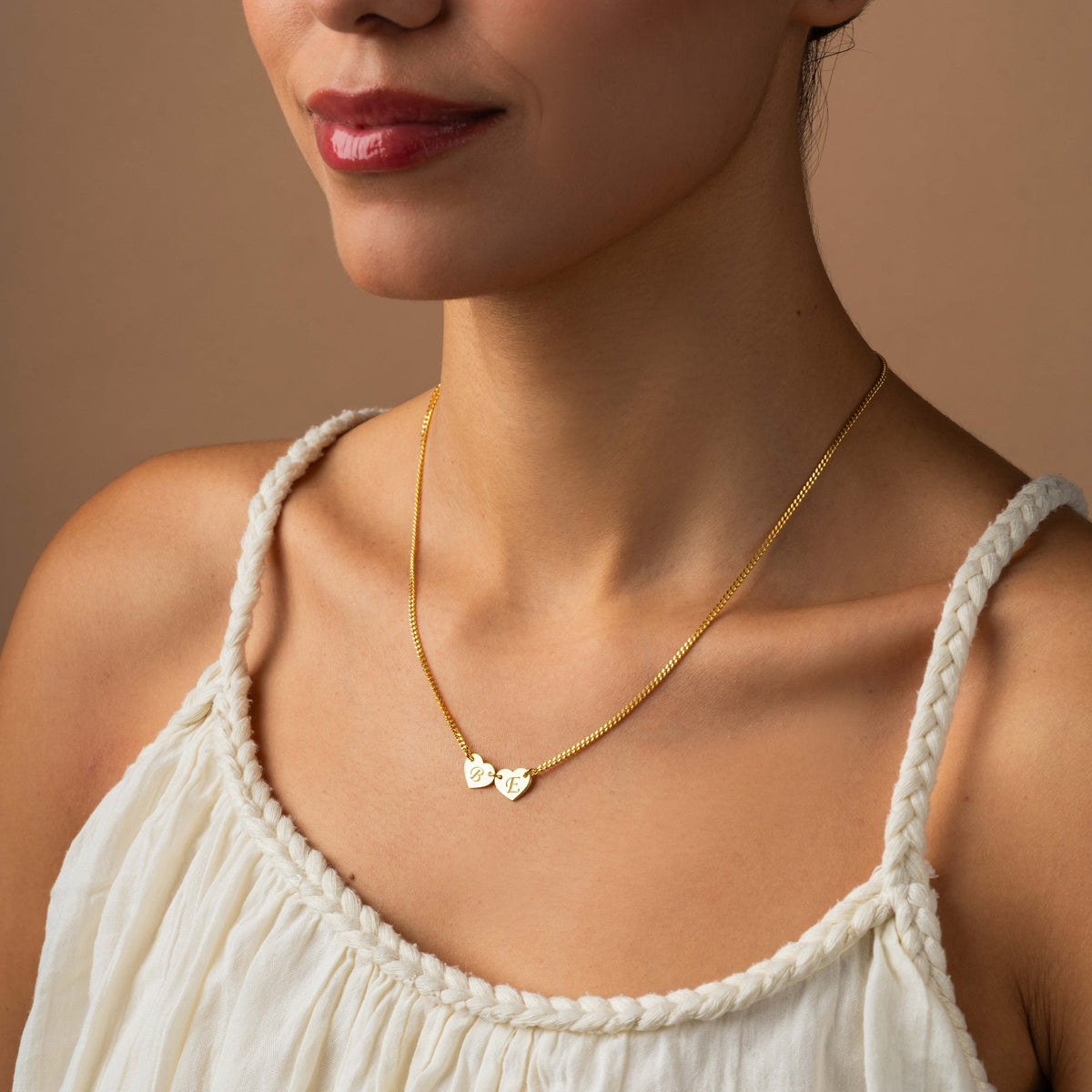 Personalized two heart initial necklace on model, curb chain in gold vermeil