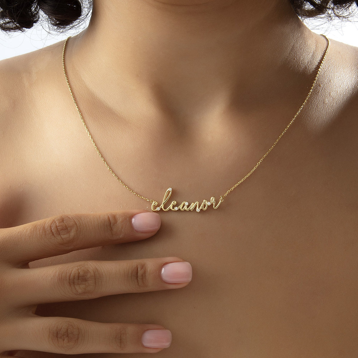 Dainty sparkly name necklace worn at the collarbone in gold vermeil