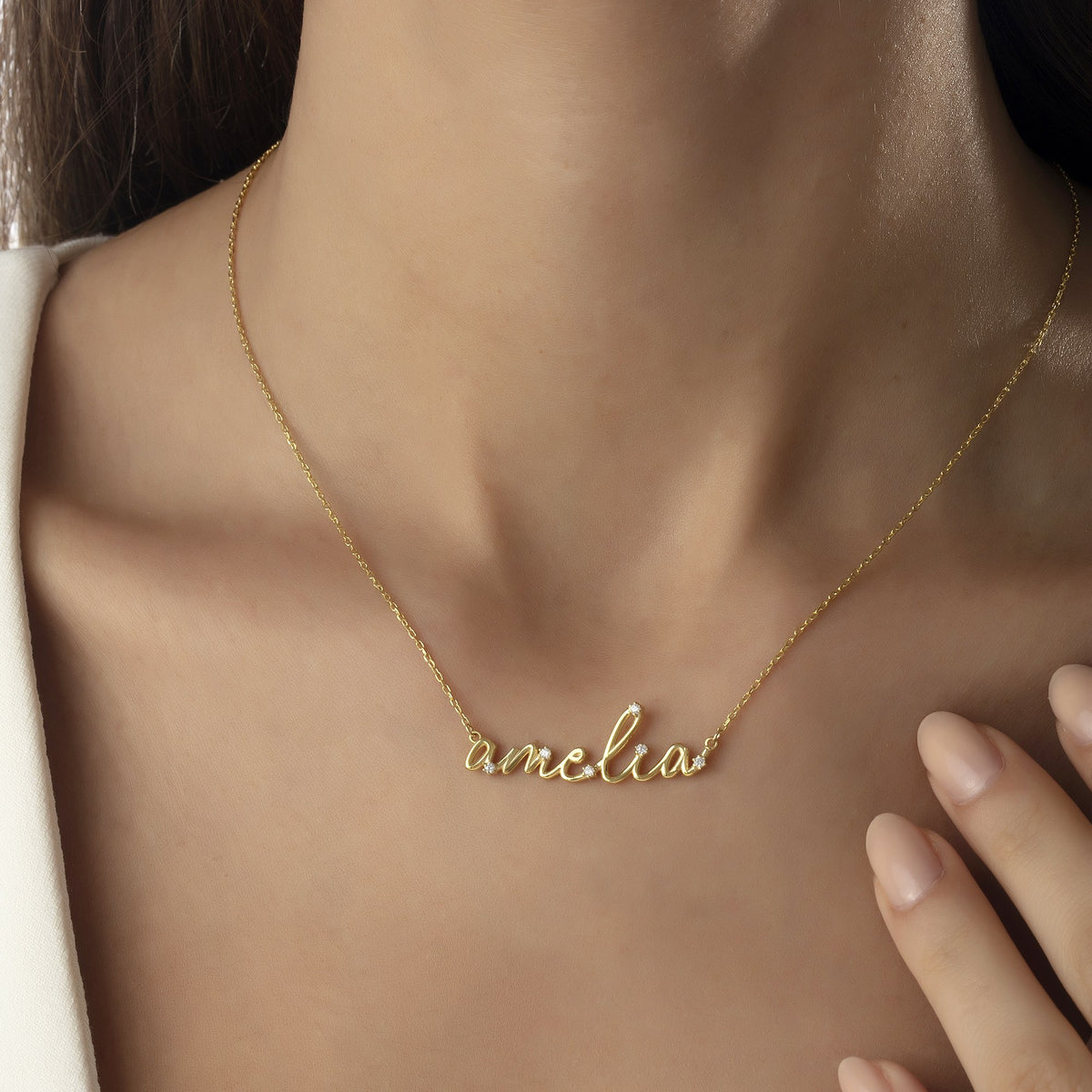 Mom wearing a cursive name necklace with her child's name in 14K gold vermeil