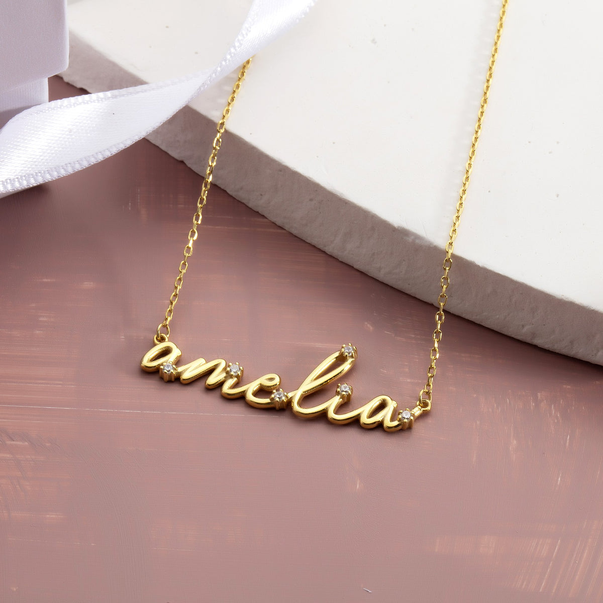 Cursive nameplate necklace gift close-up with white ribbon
