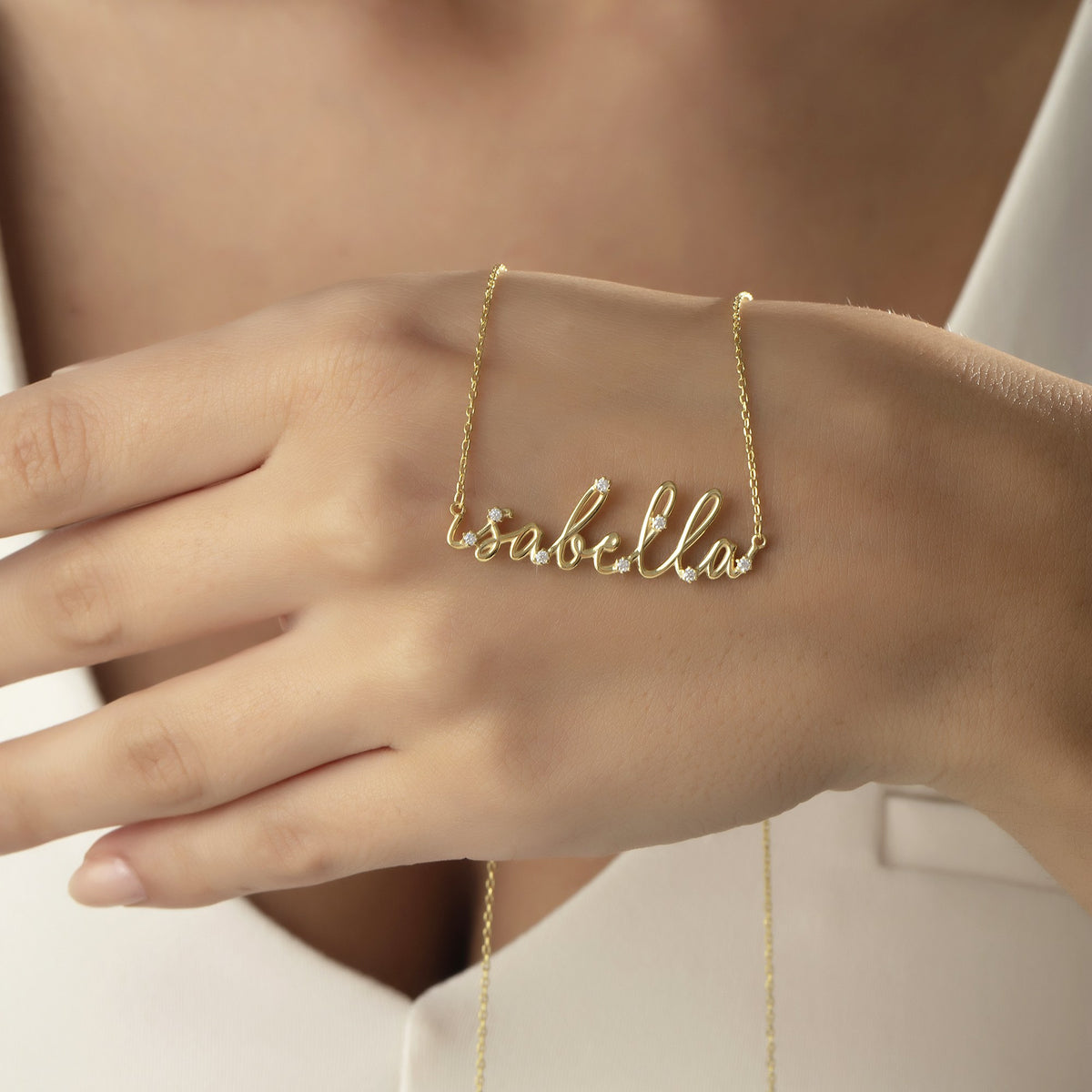 Minimalist personalized name necklace draped over a hand
