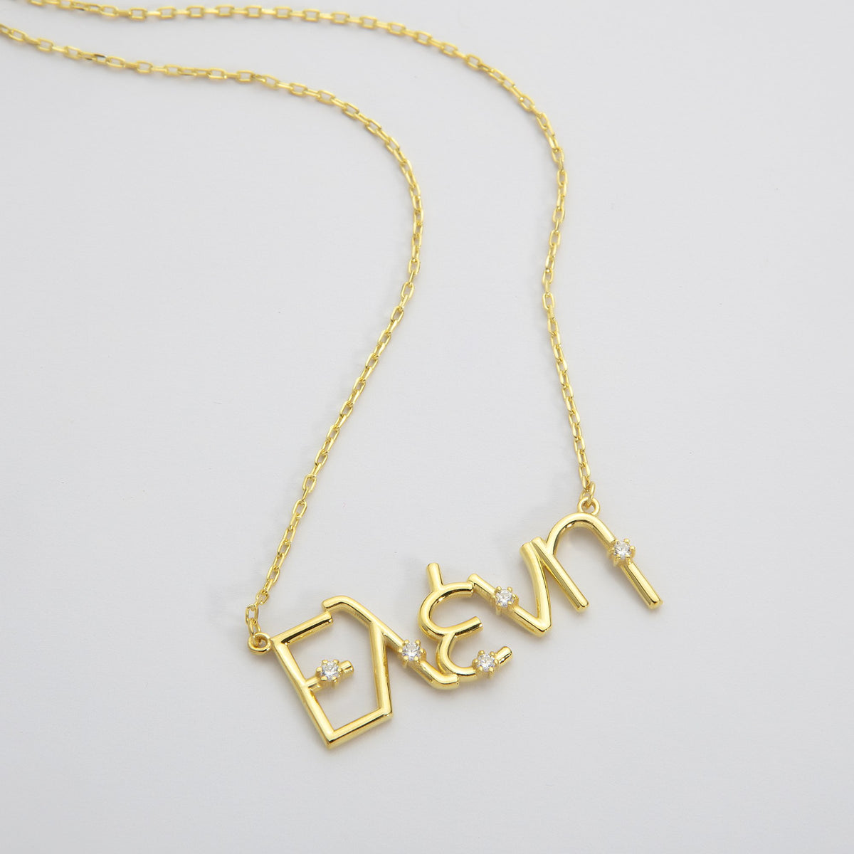 Gold Greek nameplate necklace spelling a name in Greek letters on a cable chain