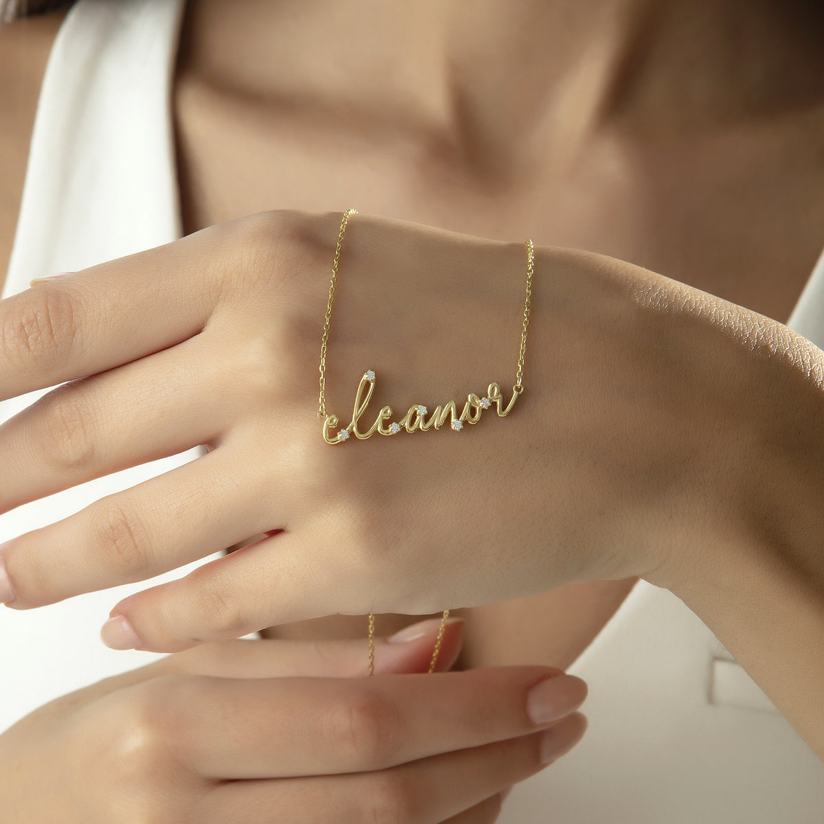 Sparkle name necklace with CZ stones draped over a hand